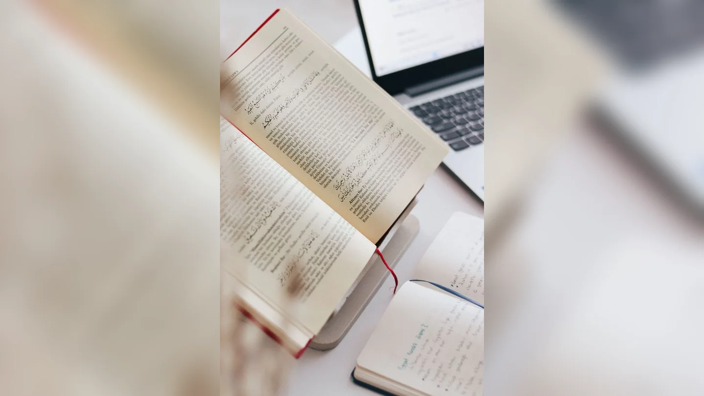 Book, notes and laptop on a desk