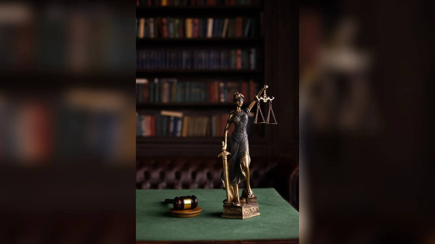 Lady Justice statue and gavel beside law books