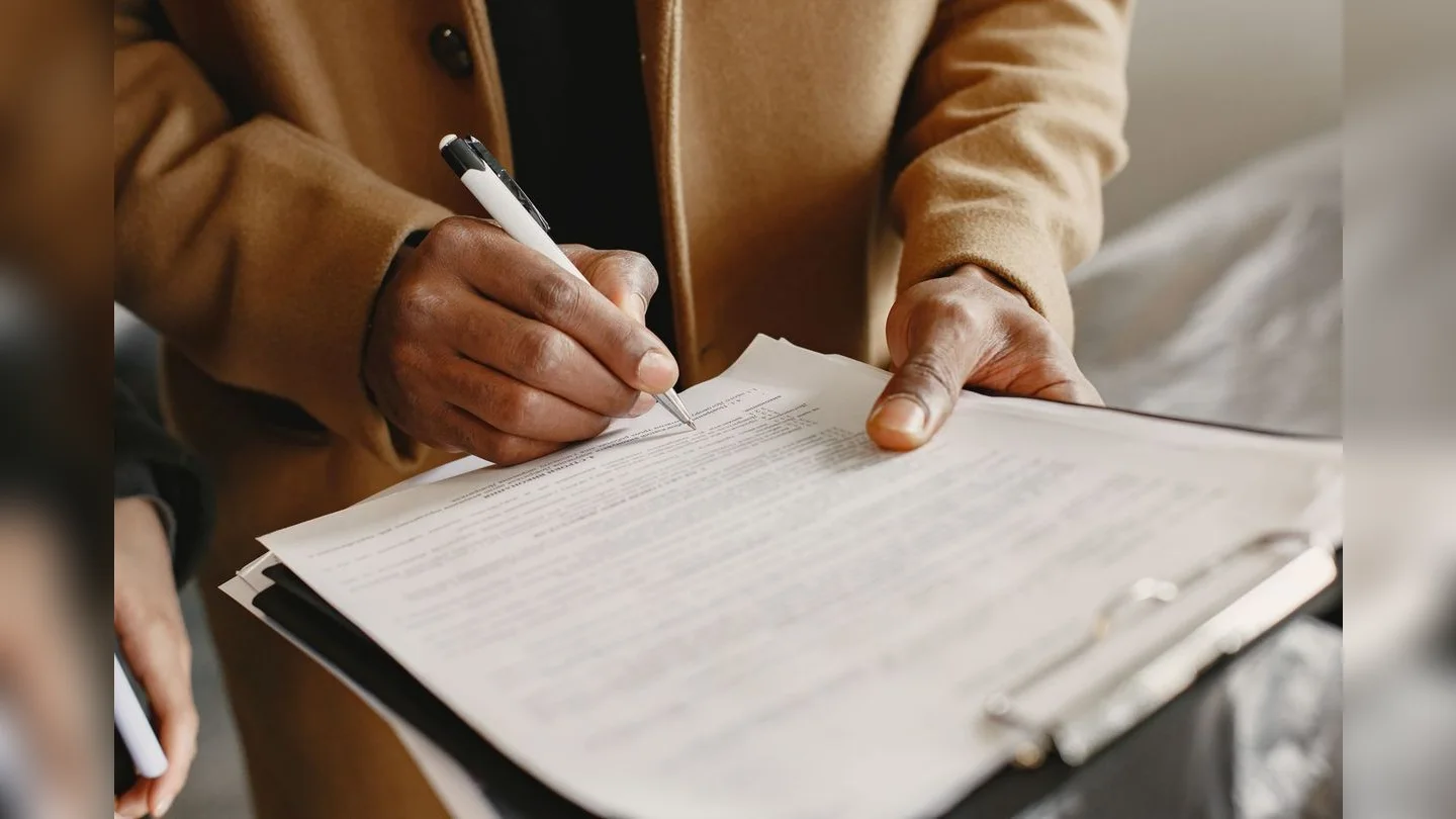Hands completing a form on a clipboard