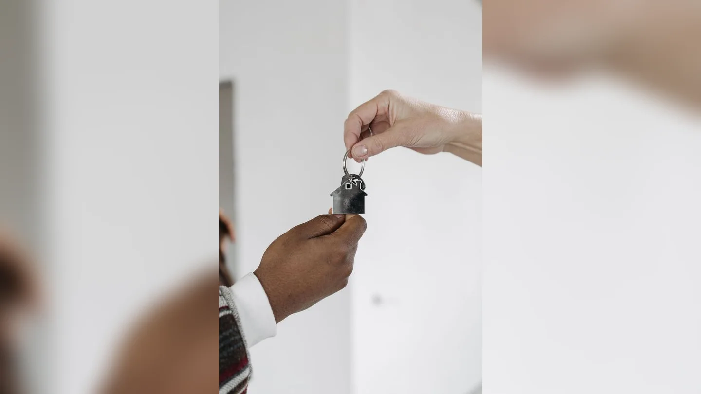 Hands exchanging a house key
